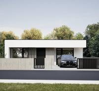 Ein Einfamilienhaus in Nesvady mit einer Betonmauer und einer Garage neben einer grünen Umgebung.