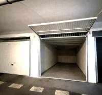 Offene Garage mit leerem Innenraum und weißen Wänden.