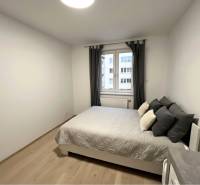 Schlafzimmer mit Bett und Holzboden in einer 2-Zimmer-Wohnung.