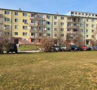 Ein Plattenbau in der Prachatická Straße in Zvolen, vor dem Autos parken.