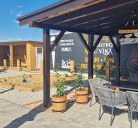 Außenbereich in Nová Dedinka mit Gastronomieräumen, Terrasse und Kinderspielplatz.