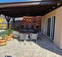 Gastronomiebereiche in Nová Dedinka mit Außensitzplätzen und Ziegelmauer.