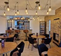 Gastronomiebereiche mit Holzboden und hängenden Glühbirnen.