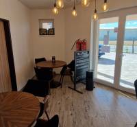 Innenraum von Gastronomiebereichen mit Holzdekor und einem Fenster, das einen Ausblick nach draußen bietet.