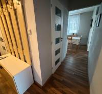 Der Flur in einer 3-Zimmer-Wohnung mit einem Holzboden und einem Tisch am Fenster.