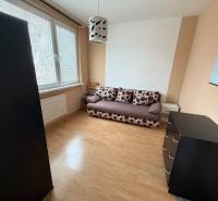 Ein Zimmer mit einem Sofa, einer Kommode und einem Boden in Holzoptik in einer 3-Zimmer-Wohnung.