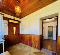 Holzverkleidung an Wänden und Decke, bunter Kronleuchter, Tisch in einem Einfamilienhaus.