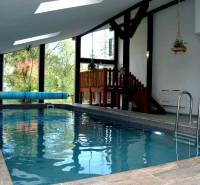 Innenraum einer Ferienwohnung mit Holzboden und überdachtem Pool.