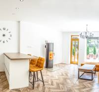 Helle Ferienwohnung mit Küche, orangefarbenem Sofa und Holzdekorboden.