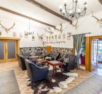 Innenraum einer Ferienwohnung mit Ledersofa, Ecken und Boden in Holzoptik.