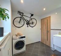 Badezimmer in einer 2-Zimmer-Wohnung mit Fahrrad, Waschmaschine und Fliesen.