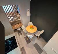 Küchenecke in einer 2-Zimmer-Wohnung mit Esstisch und Stühlen.