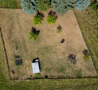 Luftaufnahme eines Wohnbaugrundstücks in Banská Belá mit Rasenfläche und Bäumen.