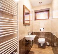 Badezimmer in einem Einfamilienhaus mit Holzboden, Waschbecken und Heizkörper.