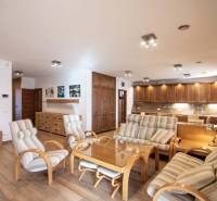 Innenraum eines Einfamilienhauses mit geräumigem Wohnzimmer, Küchenzeile und Boden mit Holzdekor.