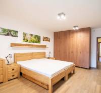 Ein Schlafzimmer in einem Einfamilienhaus mit Bett, Schränken und einem Boden in Holzoptik.