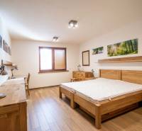 Schlafzimmer mit Holzmöbeln und Bodenbelag in Holzoptik im Einfamilienhaus.