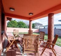 Die Terrasse des Einfamilienhauses in der Krajná-Straße in Stupava mit Holzmöbeln und Ziegelwänden.