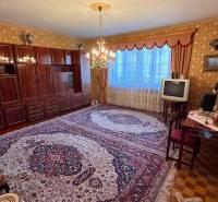 Wohnzimmer in einem Einfamilienhaus mit Teppich, älterem Fernseher und elegantem Kronleuchter.