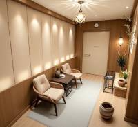 Innenraum eines Einfamilienhauses mit hellen Blumen, bequemen Sesseln und einem Boden in Holzoptik.