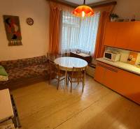 Innenraum eines Einfamilienhauses mit Retro-Küche, rundem Tisch und Sofa.