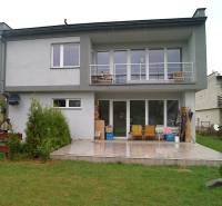 Einfamilienhaus in Bystrička, Terrasse mit Sitzgelegenheit, große Fenster und gepflegter Rasen.