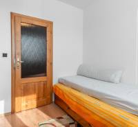 Einfaches Zimmer in einer 4-Zimmer-Wohnung mit Bett und Boden in Holzoptik.