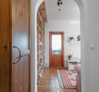 Wohnzimmer einer Vierzimmerwohnung mit gemustertem Teppich, Schaukelkronleuchter und Holztüren.