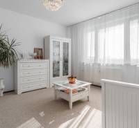 Helles Zimmer mit einer Glasvitrine, weißen Möbeln und Pflanzen in einer 4-Zimmer-Wohnung.