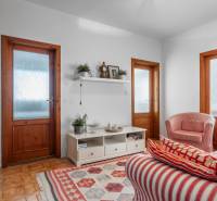 Wohnzimmer in einer 4-Zimmer-Wohnung mit rot gestreiften Sesseln und einem Regal an der Wand.