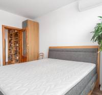 Schlafzimmer in einer 4-Zimmer-Wohnung mit Bett, Einbauschrank und Bücherregal.