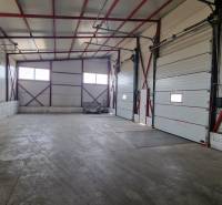 Ein geräumiger Raum mit hoher Decke und großen Toren in Skados und Hallen.