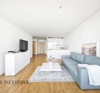 Wohnzimmer mit blauem Sofa, weißen Möbeln und Holzboden in einer 2-Zimmer-Wohnung.