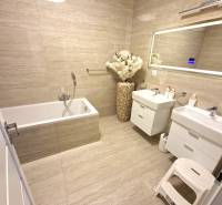 Ein Badezimmer im Einfamilienhaus mit Badewanne, Doppelwaschbecken und dekorativer Vase.