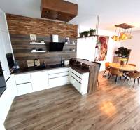 Eine Küche in einem Einfamilienhaus mit einem Holzboden, einem Esstisch und dekorativen Lichtern.