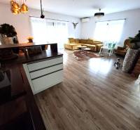 Wohnzimmer in einem Einfamilienhaus mit Holzboden und heller Couch.