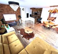 Wohnzimmer mit Sofa, Esstisch und Holzboden in einem Einfamilienhaus.