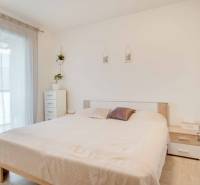 Helles Schlafzimmer in einer 3-Zimmer-Wohnung mit weißen Möbeln und Bett.