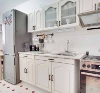 Küche in einer 3-Zimmer-Wohnung mit weißen Schränken, Herd und großem Kühlschrank.