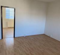 Ein Zimmer in einer 3-Zimmer-Wohnung mit weißen Wänden und einem Boden in Holzoptik.