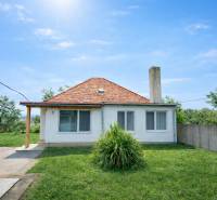 Ein Einfamilienhaus in Veľké Ripňany mit Garten, Schrägdach und Rasenhof.