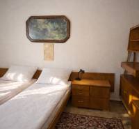 Schlafzimmer im Einfamilienhaus mit zwei Betten, einem Nachttisch und einem Bild an der Wand.