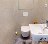 Kompaktes Badezimmer mit hellen Fliesen, Waschbecken und Toilette in einer 3-Zimmer-Wohnung.