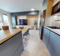 Küche in einer 3-Zimmer-Wohnung mit Holzboden und Esstisch.