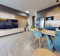 Wohnzimmer in einer 3-Zimmer-Wohnung mit Holzboden und Küche.