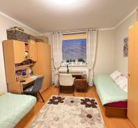 Ein Zimmer in einer 3-Zimmer-Wohnung mit einem Schreibtisch, einem Holzboden und zwei Betten.