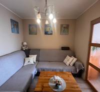 Wohnzimmer in einer 3-Zimmer-Wohnung mit Sofa, Bildern und Holzboden.