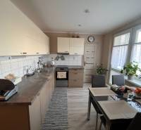 Küche in einer 3-Zimmer-Wohnung mit Tisch, Geräten und Pflanzen.