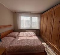 Schlafzimmer in einer 3-Zimmer-Wohnung mit einem großen Holzschrank und einem Bett.