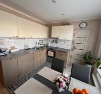 Küche in einer 3-Zimmer-Wohnung mit hellen Schränken und Esstisch.